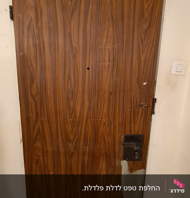 דלת עץ עם ציפוי מתקלף בחלק התחתון